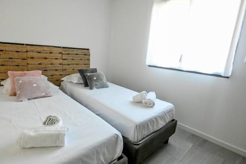 deux lits dans une chambre avec des murs et des fenêtres blancs dans l'établissement Milla - Panoramic Terrace Calm & Cosy - by TGB, à Porticcio