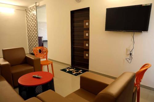 a living room with a couch and a flat screen tv at Horizon Grande Apartments - Tarkarli in Malvan