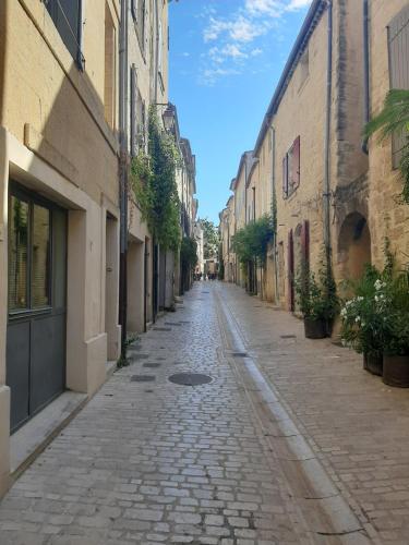 an empty street in an alley with buildings at Appartement avec grand jardin et parking, Uzès in Uzès