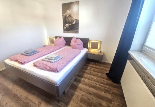 - une chambre avec 2 lits et des oreillers roses dans l'établissement Ferienwohnung Gipfelstürmer, à Blaichach