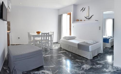 a white room with two beds and a table at Hotel Korali in Troulos