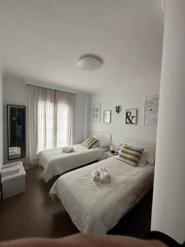a bedroom with two beds with stuffed animals on them at El pasaje Apart in Ronda