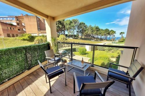 d'un balcon avec des chaises et des tables offrant une vue sur l'océan. dans l'établissement Stella - Agosta beach by foot Terrace - by TGB, à Porticcio