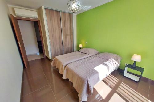 - une chambre avec un lit dans un mur vert dans l'établissement Stella - Agosta beach by foot Terrace - by TGB, à Porticcio