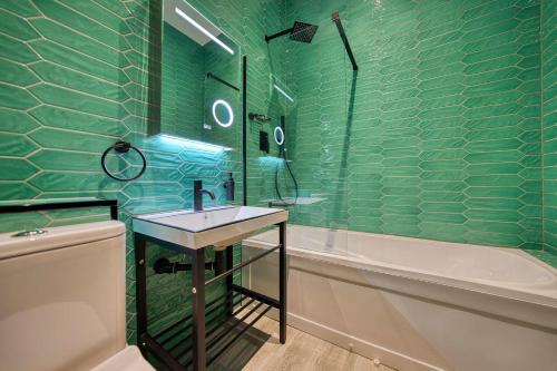 a green tiled bathroom with a sink and a tub at Spacious Central Station 2 Bed Apartment B3 in Glasgow