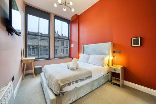 a bedroom with orange walls and a bed and a window at Spacious Central Station 2 Bed Apartment B3 in Glasgow