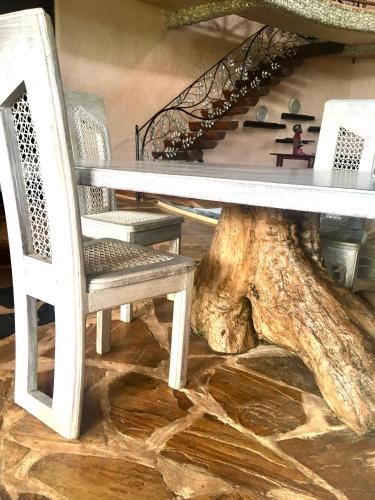 a table and a chair next to a tree stump at Colobus Suite of 40m2 in Villa 560 m2, View of the Indian Ocean in Shimoni