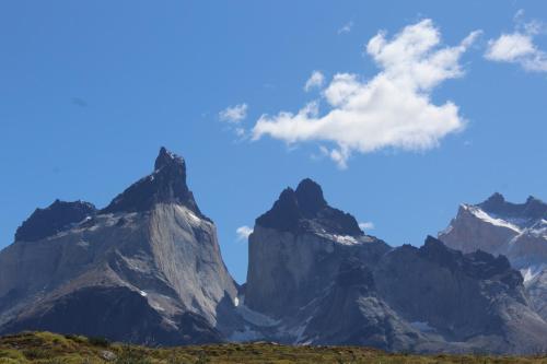 a mountain range with a blue sky and clouds at Cabañas y Casa Kauken in Puerto Natales