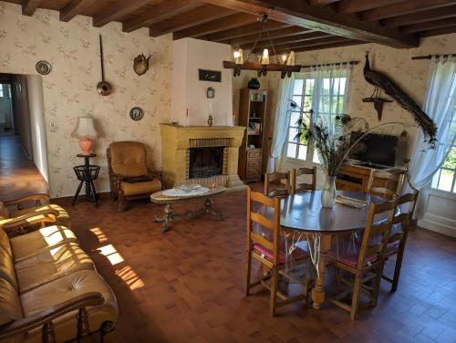 un salon avec une table et une cheminée dans l'établissement Maison indépendante calme et nature, à Pereyrols