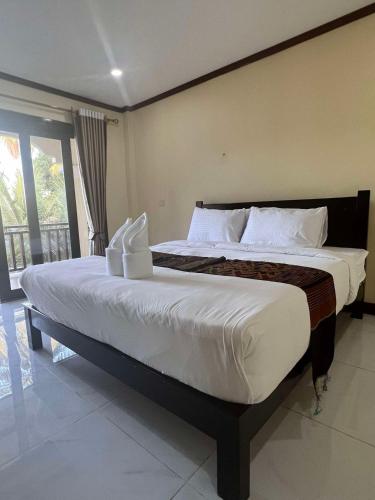 a bedroom with a large bed with white sheets at Lebijou Guesthouse - Konesavath in Don Det
