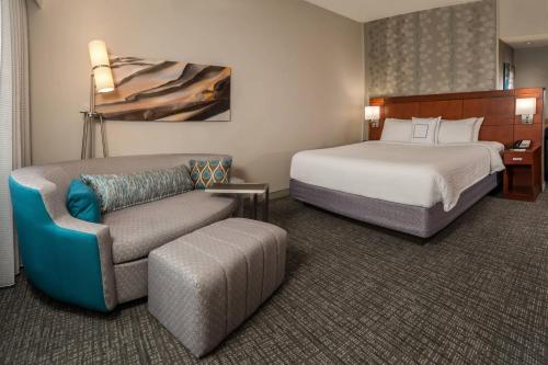 a hotel room with a bed and a couch at Courtyard by Marriott Hagerstown in Hagerstown