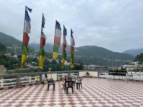 a group of flags on a roof with tables and chairs at JC Homestay, Dirang in Dirang Dzong