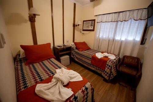 a hotel room with two beds with towels on them at Hotel Gran Litoral in Concepción del Uruguay