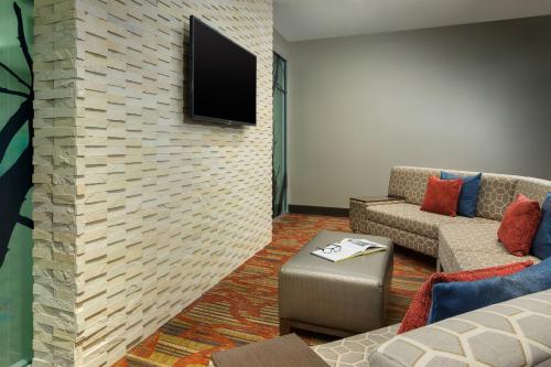 a living room with a tv on a brick wall at Courtyard New York Manhattan/Upper East Side in New York