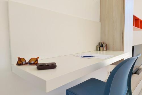 un comptoir blanc avec un sac et une chaise bleue dans l'établissement Amalia - Sea view terrace Wifi Parking - by TGB, à Porticcio