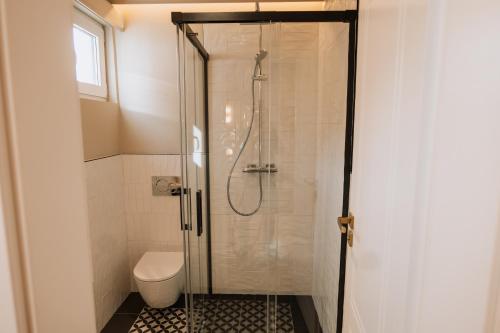 a bathroom with a shower with a toilet at Parc Suites by Hotel Cerbul in Sinaia