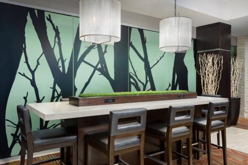 a dining room with a green wall and a table with chairs at Courtyard New York Manhattan/Upper East Side in New York