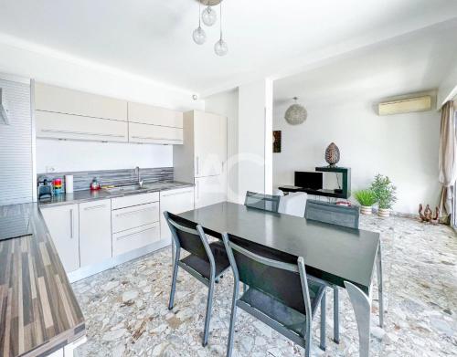 - une cuisine avec une table à manger et des chaises noires dans l'établissement Le SORRENTO, à Antibes