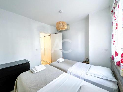 une chambre avec deux lits et une fenêtre dans l'établissement Le SORRENTO, à Antibes