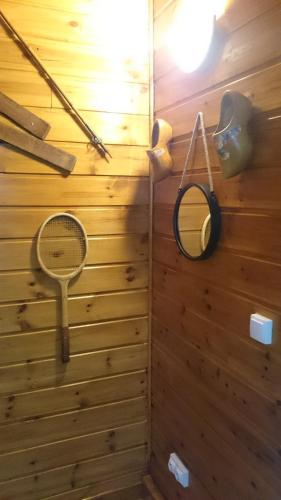 un mur en bois avec une raquette de tennis et un miroir dans l'établissement Chalet Espace Lumière - Spa, sauna et salle de fitness, à Méolans
