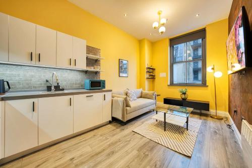 a kitchen and a living room with yellow walls at Lovely Central Station 1 Bed Apartment B10 in Glasgow