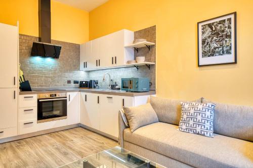 a living room with a couch and a kitchen at Lovely Central Station 1 Bed Apartment B10 in Glasgow