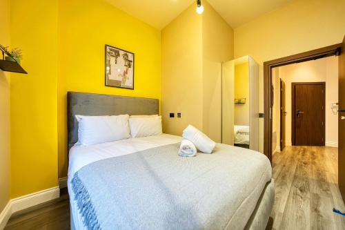 a bedroom with a large bed with yellow walls at Lovely Central Station 1 Bed Apartment B10 in Glasgow