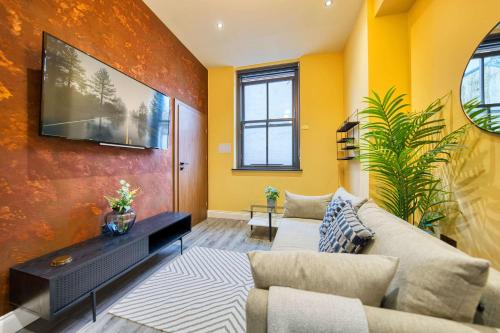 a living room with yellow walls and a couch at Smart Central Station 1 Bed Apartment B11 in Glasgow