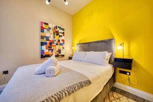 a bedroom with a bed with a yellow wall at Smart Central Station 1 Bed Apartment B11 in Glasgow