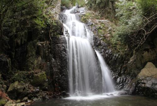 a waterfall on the side of a rocky cliff at Villa Isola Bella - Vintage in Mògoro