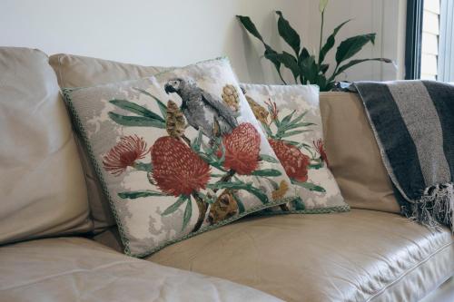 a couch with two pillows with a bird on it at Halls Gap Escape Townhouses in Halls Gap