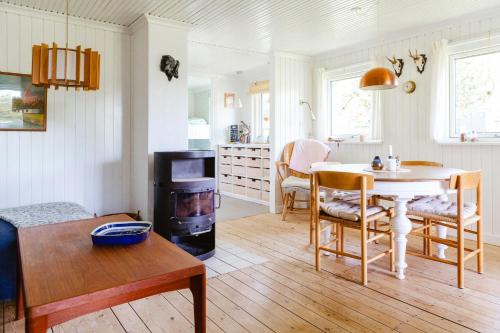 una cucina e un soggiorno con tavolo e piano cottura di Romantic Island Cottage In Cosy Style Near Beach a Maribo