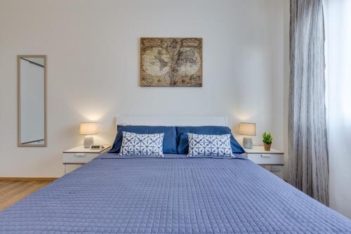 a bedroom with a blue bed with two lamps at Rooms Vidar Train Station in Marghera