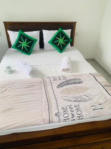 a bed with green and white blankets and pillows at Broad view in Ella