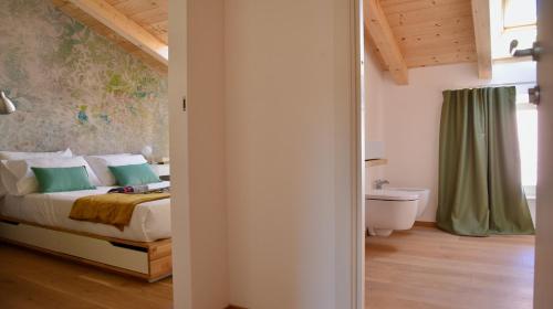a bedroom with a bed and a toilet in a room at Nine Rooms Double in Trento