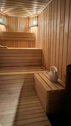 a sauna with a white vase sitting on a bench at Cozy Log Cabin With A View Over Hedmarken in Løten