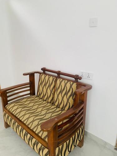 a wooden bench sitting against a white wall at Broad view in Ella