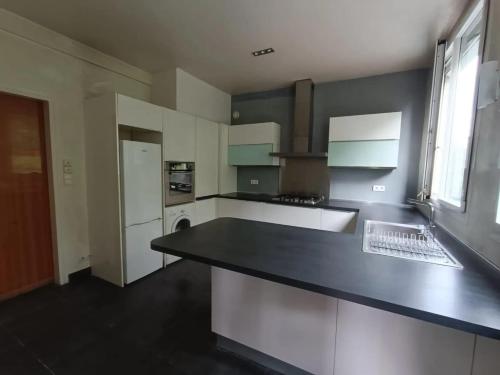 une cuisine avec un comptoir noir dans une pièce dans l'établissement Appartement spacieux à Montreuil, terrasse agréable, 150 m², à Montreuil