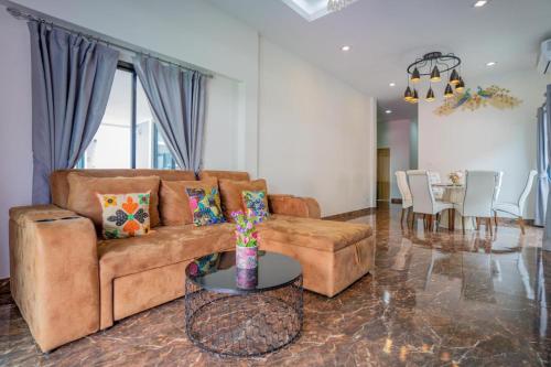 a living room with a brown couch and a dining room at Hotel Royale in Jomtien Beach