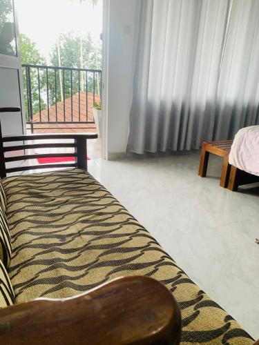 a couch in a living room with a balcony at Broad view in Ella