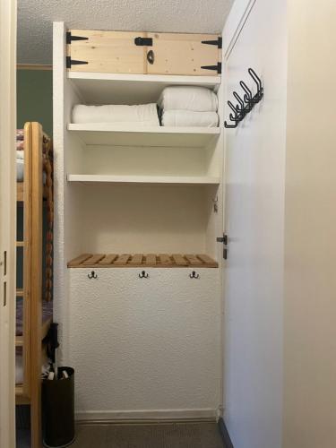 a closet with some white towels in a room at Studio chaleureux 25m2 100m du centre 3-4 personnes in Vars