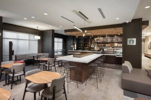 a restaurant with tables and chairs and a bar at Courtyard by Marriott Baton Rouge Downtown in Baton Rouge