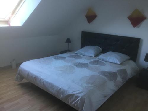 a bedroom with a large bed with white sheets at Soizic' house in Trébeurden