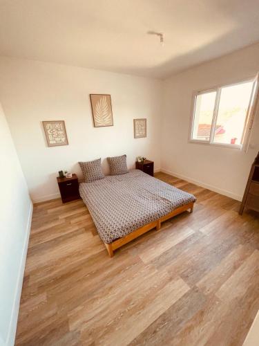 une chambre avec un lit et un parquet dans l'établissement Maison familiale, à Villenave-dʼOrnon