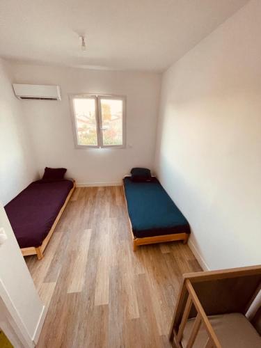 Cette chambre dispose de deux lits et de parquet. dans l'établissement Maison familiale, à Villenave-dʼOrnon