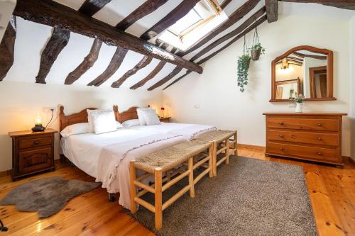 a bedroom with a large bed and a mirror at Casa Rural Casa Selmo in Carreno