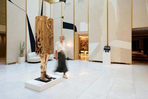 a woman walks past a mannequin in a museum at Almanac Palais Vienna in Vienna