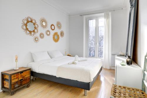 une chambre avec un lit et un miroir au mur dans l'établissement Lumineux Place du Commerce, à Paris