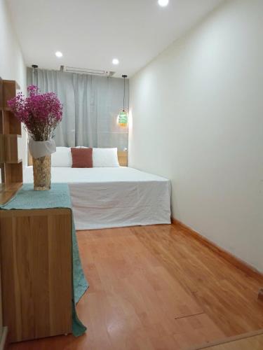 a bedroom with a bed and a vase of flowers at Luna travel in Hanoi