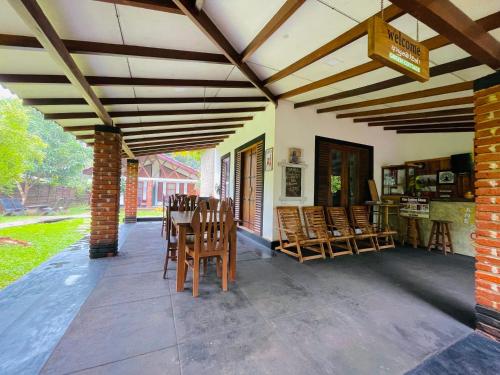 a patio with chairs and a table in a house at Green Cottage in Anuradhapura